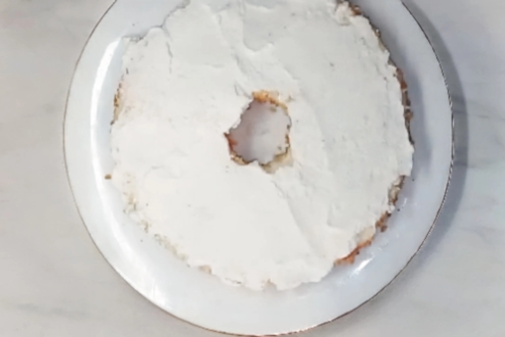 Angel food cake layer covered in whipped cream