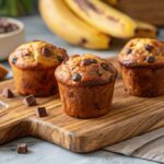 Freshly baked banana cottage cheese muffins with chocolate chips on a wooden board